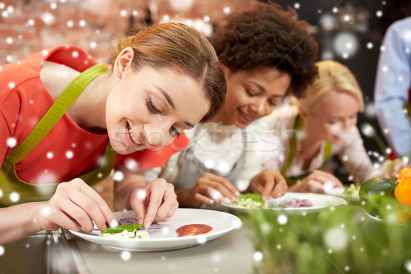 happy women cooking and decorating dishes Stock photo © dolgachov