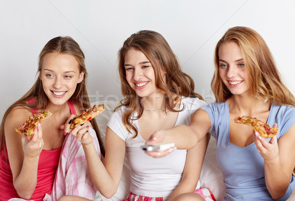 happy friends eating pizza and watching tv at home Stock photo © dolgachov