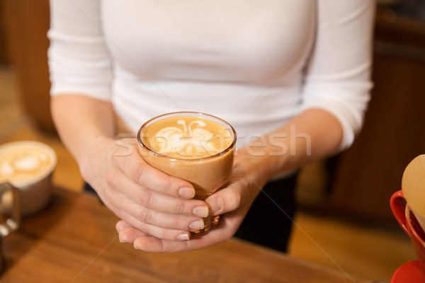 close up of hands with latte art in coffee cup Stock photo © dolgachov