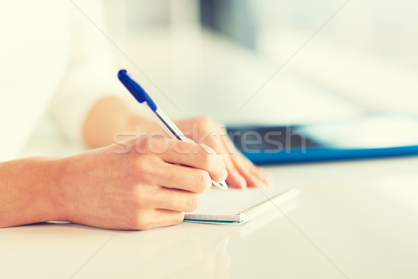 close up of hands with pen writing to notepad Stock photo © dolgachov