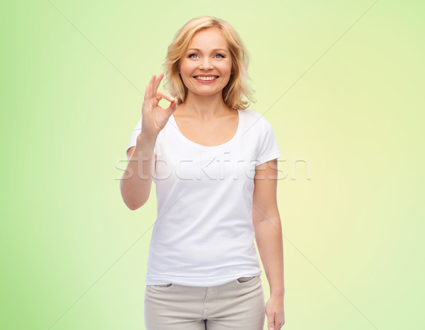Boldog nő fehér póló mutat ok Stock fotó © dolgachov