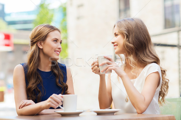 young women drinking coffee and talking at cafe Stock photo © dolgachov