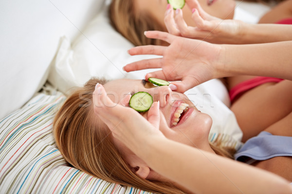 happy young women with cucumber mask lying in bed Stock photo © dolgachov
