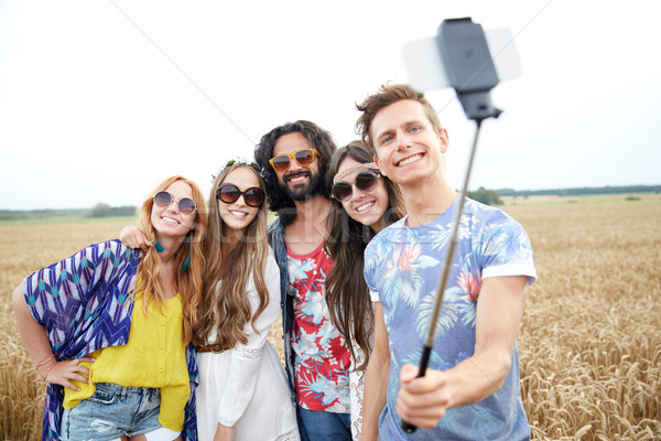 hippie friends with smartphone on selfie stick Stock photo © dolgachov