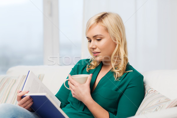  young woman with tea cup reading book at home Stock photo © dolgachov