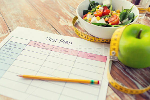 close up of diet plan and food on table Stock photo © dolgachov