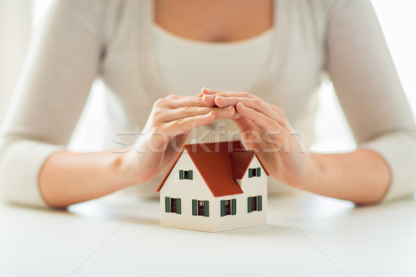 close up of hands protecting house or home model Stock photo © dolgachov