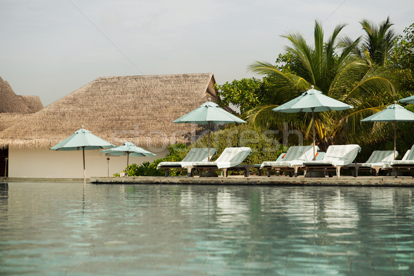 Stock photo: parasol and sunbeds by sea on maldives beach