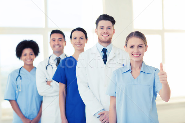 Stock photo: happy doctors showing thumbs up at hospital