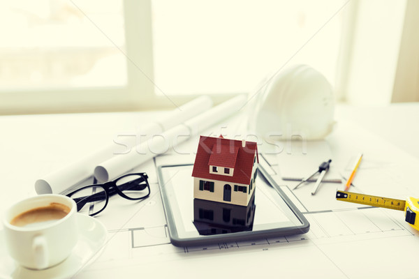 Stock photo: close up of living house model on tablet pc