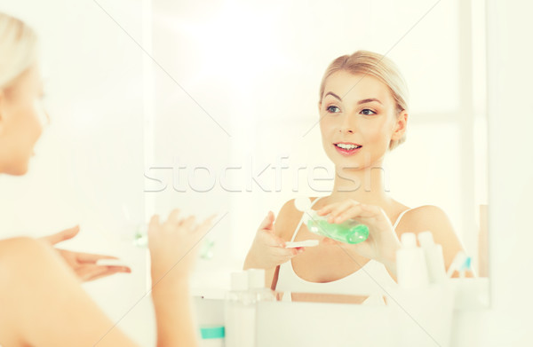 young woman with lotion washing face at bathroom Stock photo © dolgachov