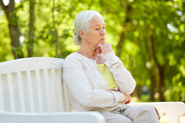 sad senior woman sitting on bench at summer park Stock photo © dolgachov