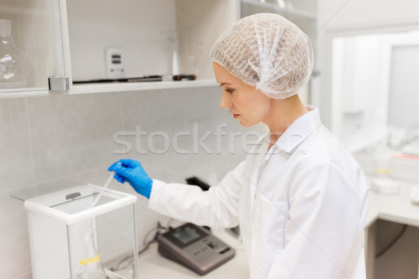 woman with sulphuric acid and scale at laboratory Stock photo © dolgachov