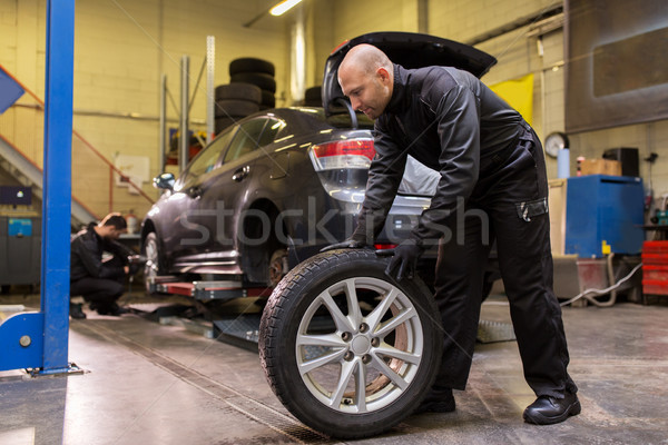 auto mechanic changing car tire at workshop Stock photo © dolgachov