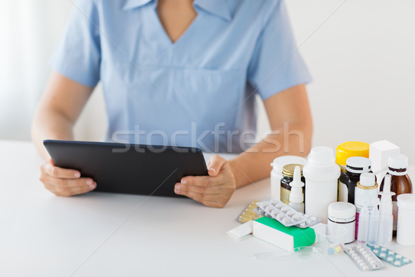nurse or doctor with medicines and tablet pc Stock photo © dolgachov