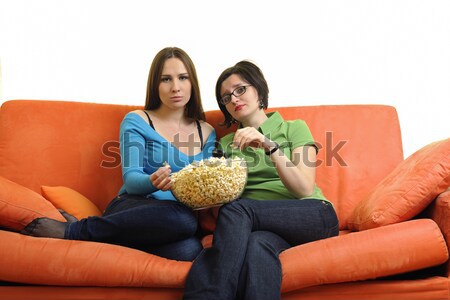 Feminino amigos alimentação pipoca assistindo tv Foto stock © dotshock