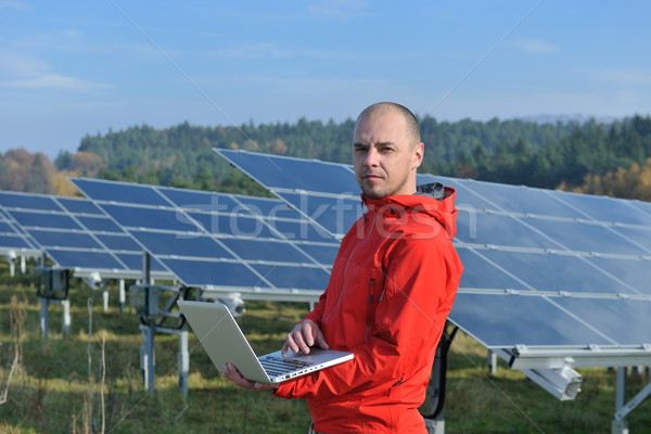 Stock photo: engineer using laptop at solar panels plant field