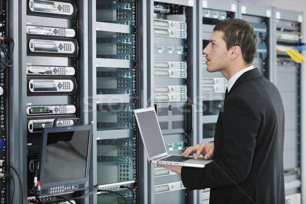 Stock photo: businessman with laptop in network server room