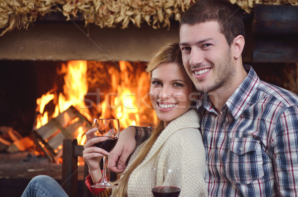 Young romantic couple sitting and relaxing in front of fireplace at home Stock photo © dotshock