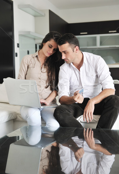 Stock photo: joyful couple relax and work on laptop computer at modern home