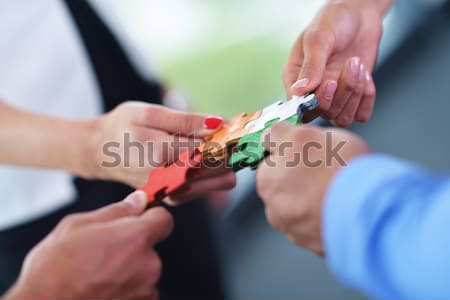 Group of business people assembling jigsaw puzzle Stock photo © dotshock