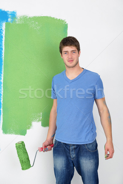 handsome young man paint white wall in color Stock photo © dotshock