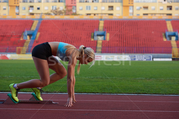 woman  sprinter leaving starting blocks Stock photo © dotshock