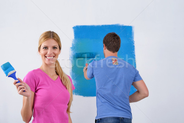 happy couple paint wall at new home Stock photo © dotshock