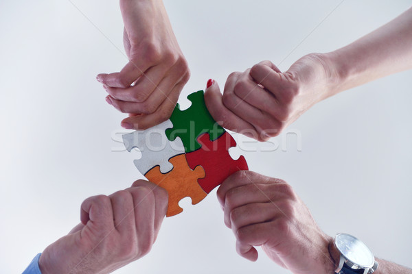 Group of business people assembling jigsaw puzzle Stock photo © dotshock