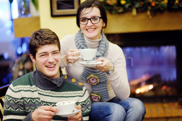 Young romantic couple relax on sofa in front of fireplace at hom Stock photo © dotshock