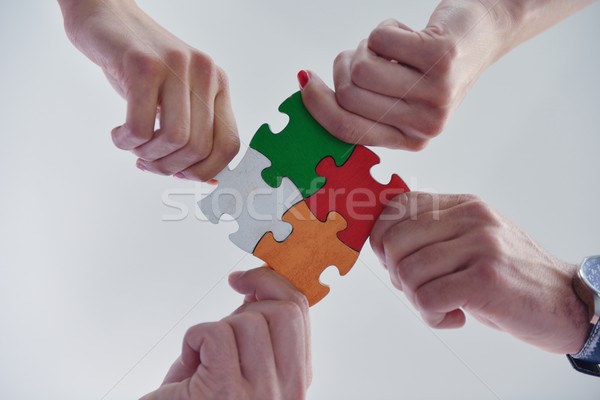 Group of business people assembling jigsaw puzzle Stock photo © dotshock