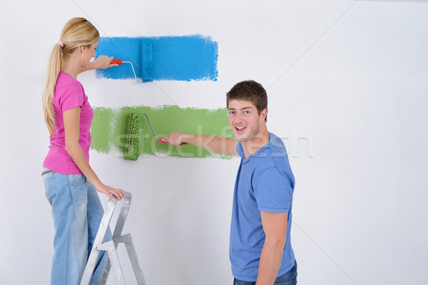 happy couple paint wall at new home Stock photo © dotshock