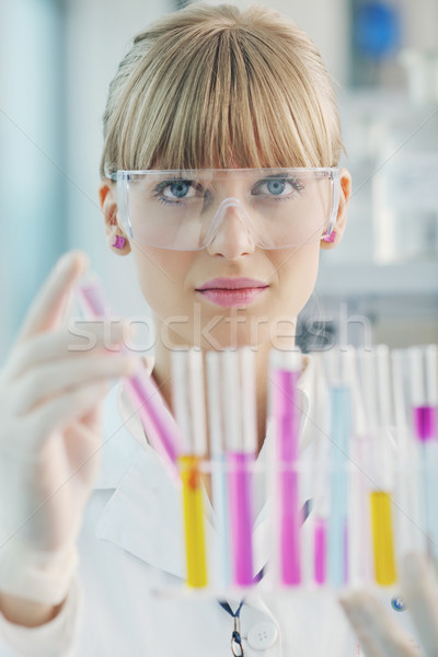 Stock photo: female researcher holding up a test tube in lab