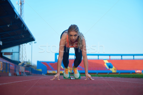 woman  sprinter leaving starting blocks Stock photo © dotshock