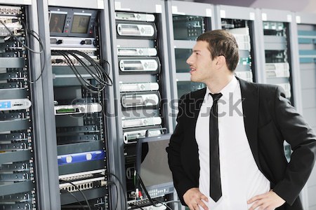Stock photo: businessman with laptop in network server room