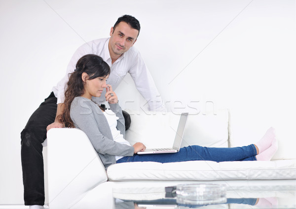 Stock photo: joyful couple relax and work on laptop computer at modern home