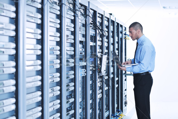 Stock photo: businessman with laptop in network server room