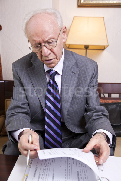 Senior Businessman Going Over Papers Stock photo © eldadcarin