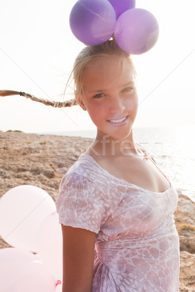 girl surrounded by balloons by the rays of sunlight Stock photo © Elegies