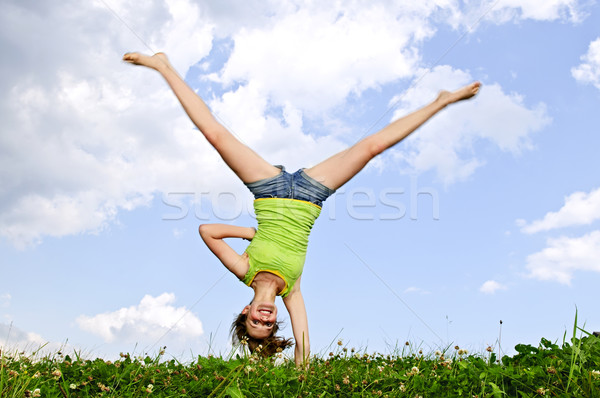 Young girl doing cartwheel Stock photo © elenaphoto