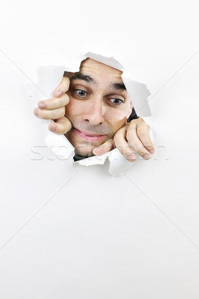 Face looking through hole in paper Stock photo © elenaphoto