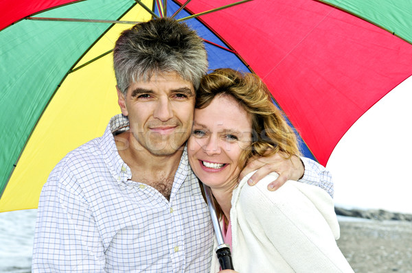 Happy mature couple with umbrella Stock photo © elenaphoto