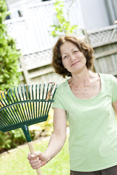 Idős nő tart gereblye nő mosolyog kerti munka Stock fotó © elenaphoto