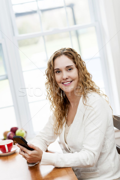 Stock photo: Smiling woman with smart phone