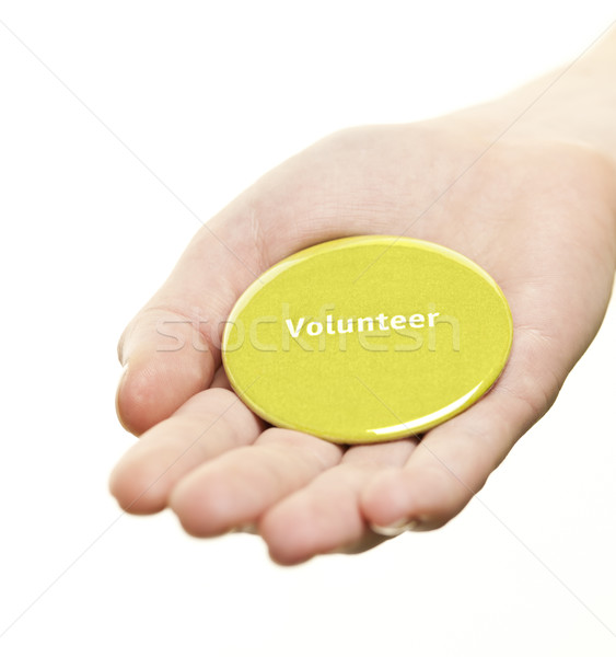 Hand holding volunteer button Stock photo © elenaphoto