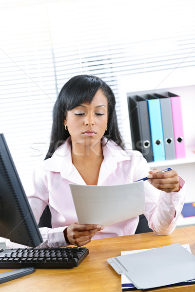 Black businesswoman working at desk Stock photo © elenaphoto