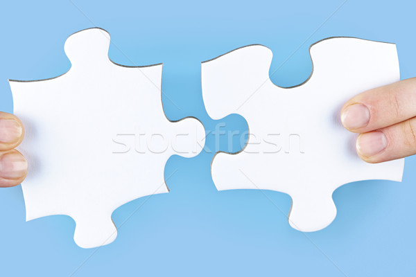 Fingers holding jigsaw puzzle pieces Stock photo © elenaphoto