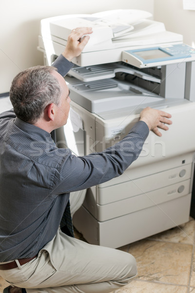 Man opening photocopier in office Stock photo © elenaphoto