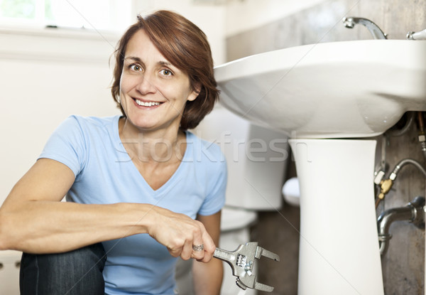 Woman fixing plumbing Stock photo © elenaphoto