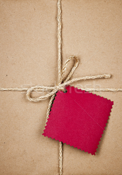 Gift with red tag in brown paper Stock photo © elenaphoto